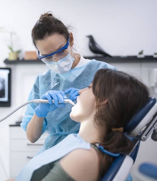 Happy young woman being examined at the dentist