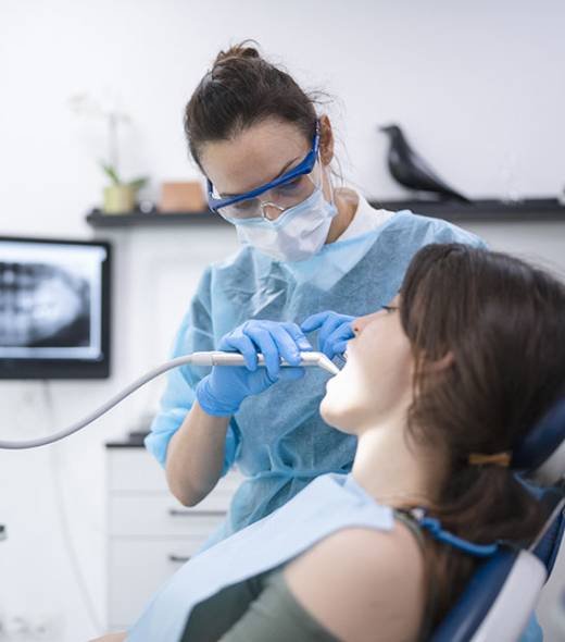 Happy young woman being examined at the dentist